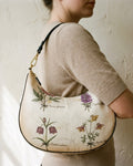 Le Demi-Lune in Herbier Royal — hero flatlay on ivory — botanical print silk twill handbag — Hoboken atelier