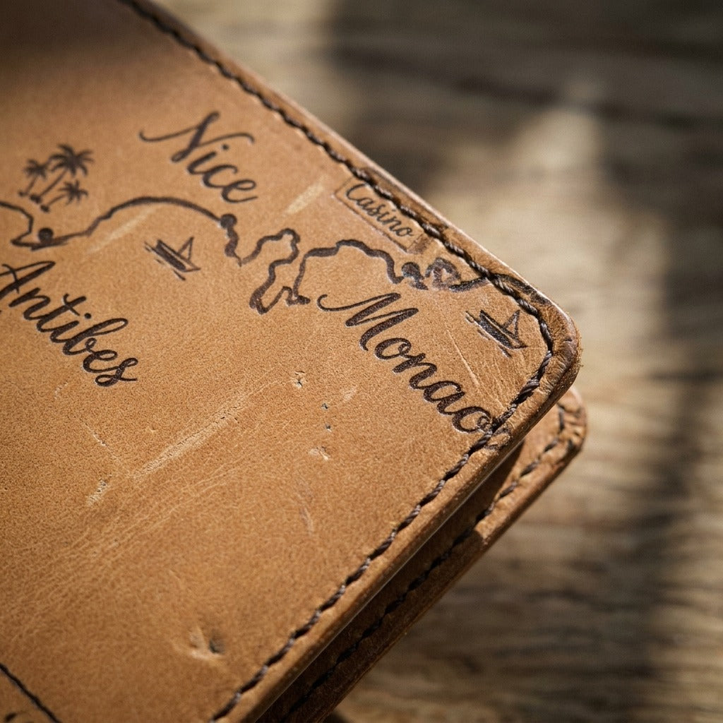 Carnet Côte d'Azur — open on a rich wood table — luxurious Italian nappa leather — Hoboken atelier